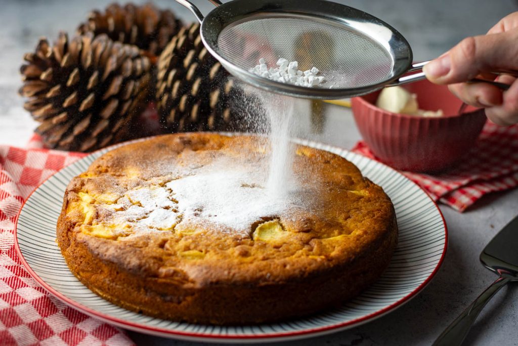 dusting apple cake with icing sugar.