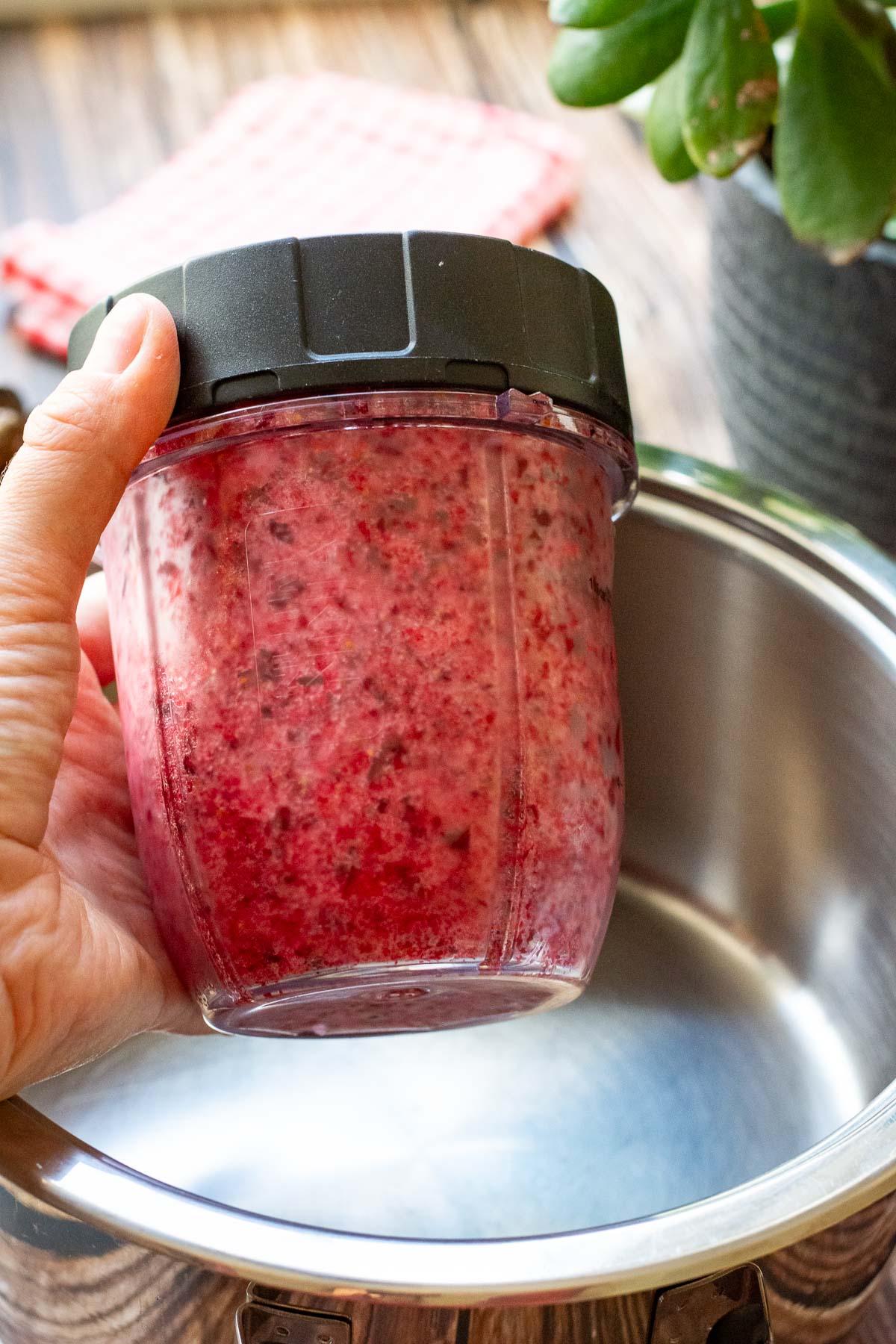Frozen cranberries blitzed into a paste in a cup of a smoothie maker.