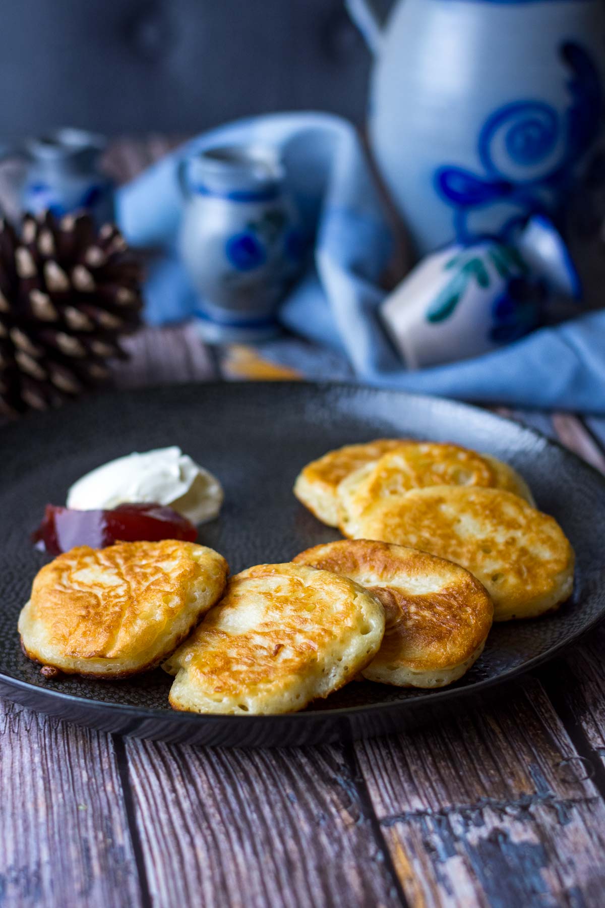 Lithuanian Yeast Pancakes on a black plate on a wooden table. 