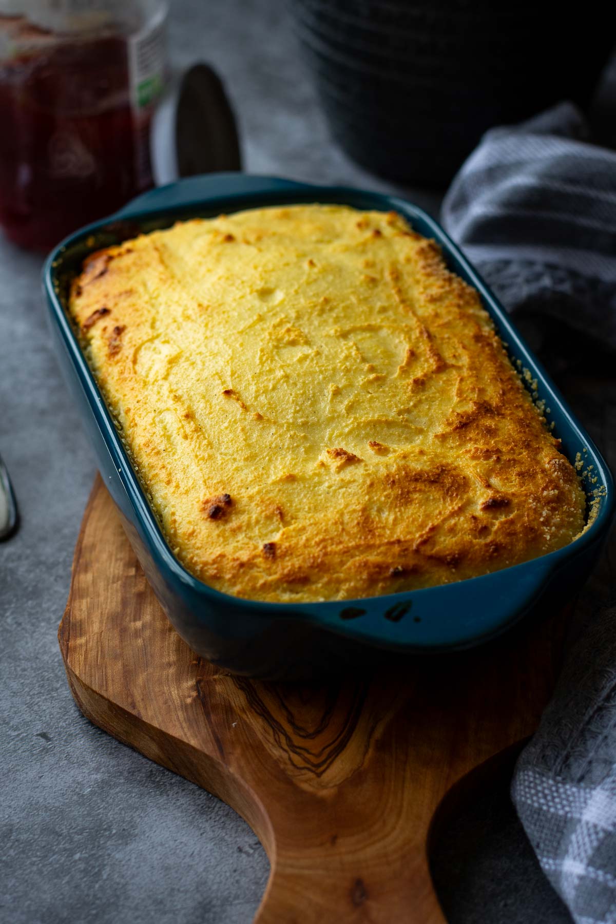 Farmer's Cheese Cheesecake in a blue baking dish on a wooden board. 