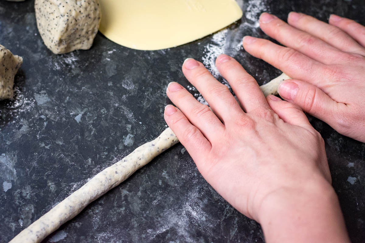 Using the palms of the hands, rolling the dough into thin strings.