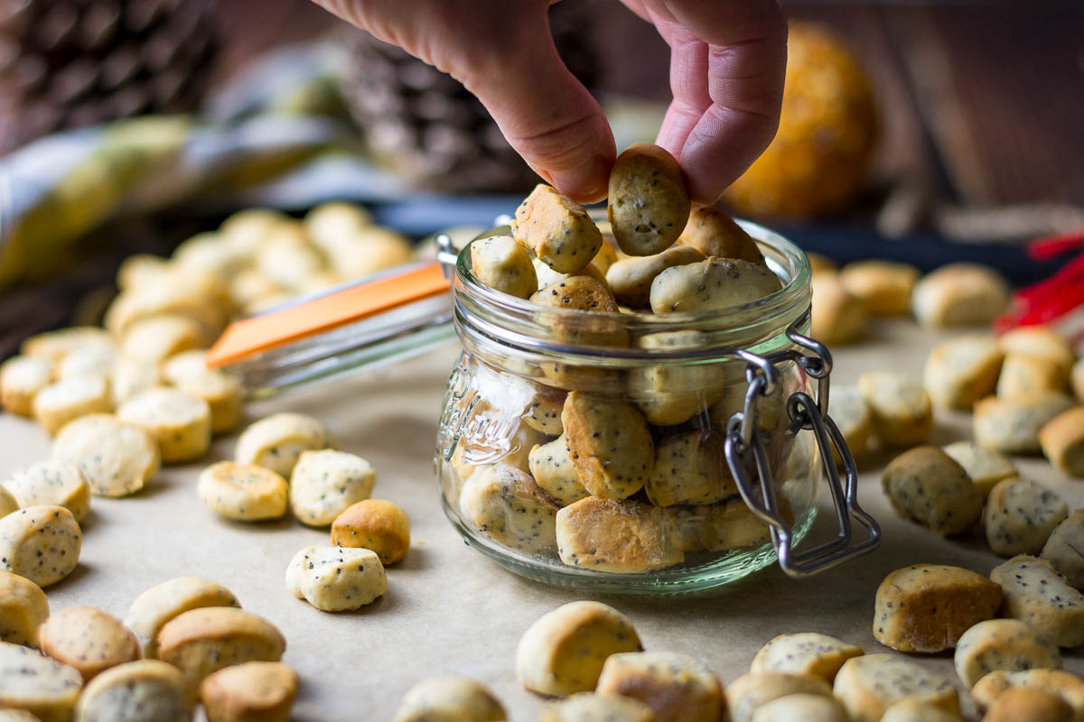 A hand picking up a Christmas Eve biscuit from a mason jar.