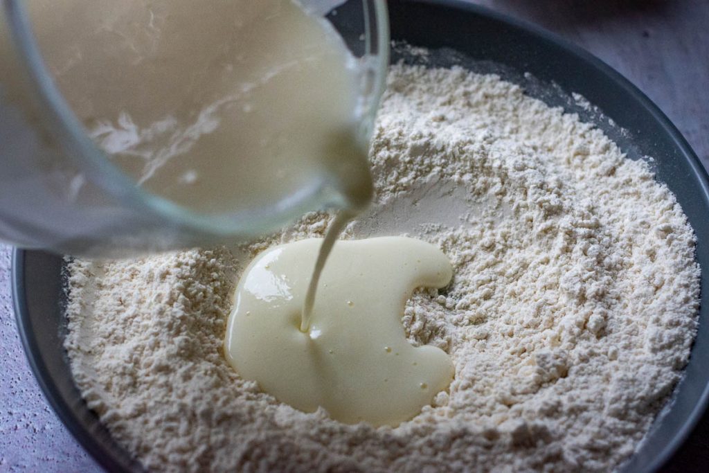 Pouring wet ingredients into the dry ingrediensts. 