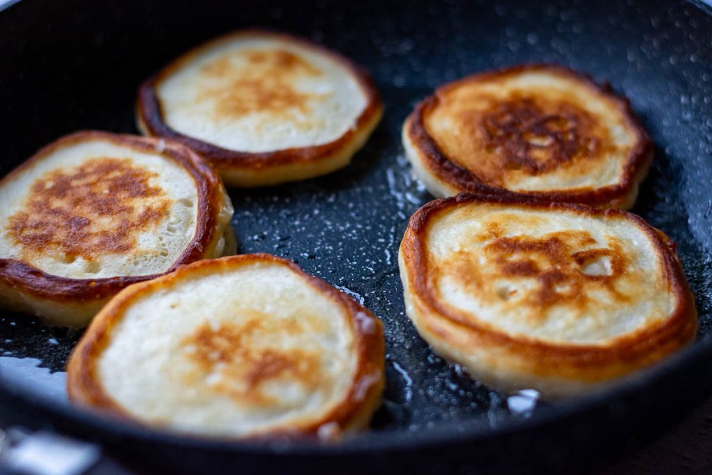 5 kefir pancakes frying on the second side. 