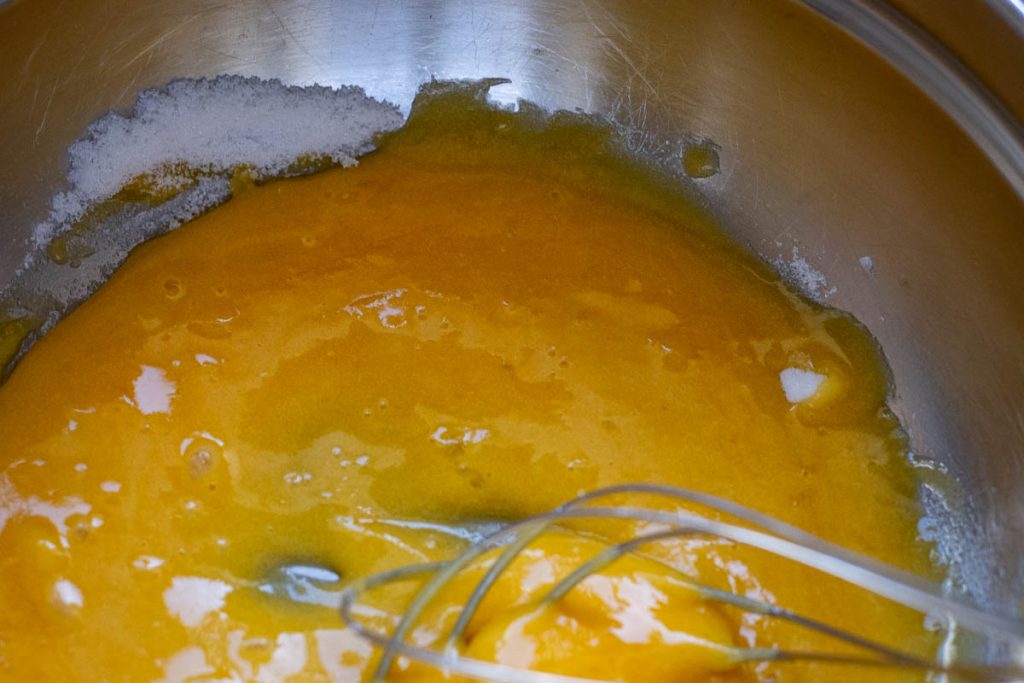 Egg yolks and sugar beaten in a large metal bowl.