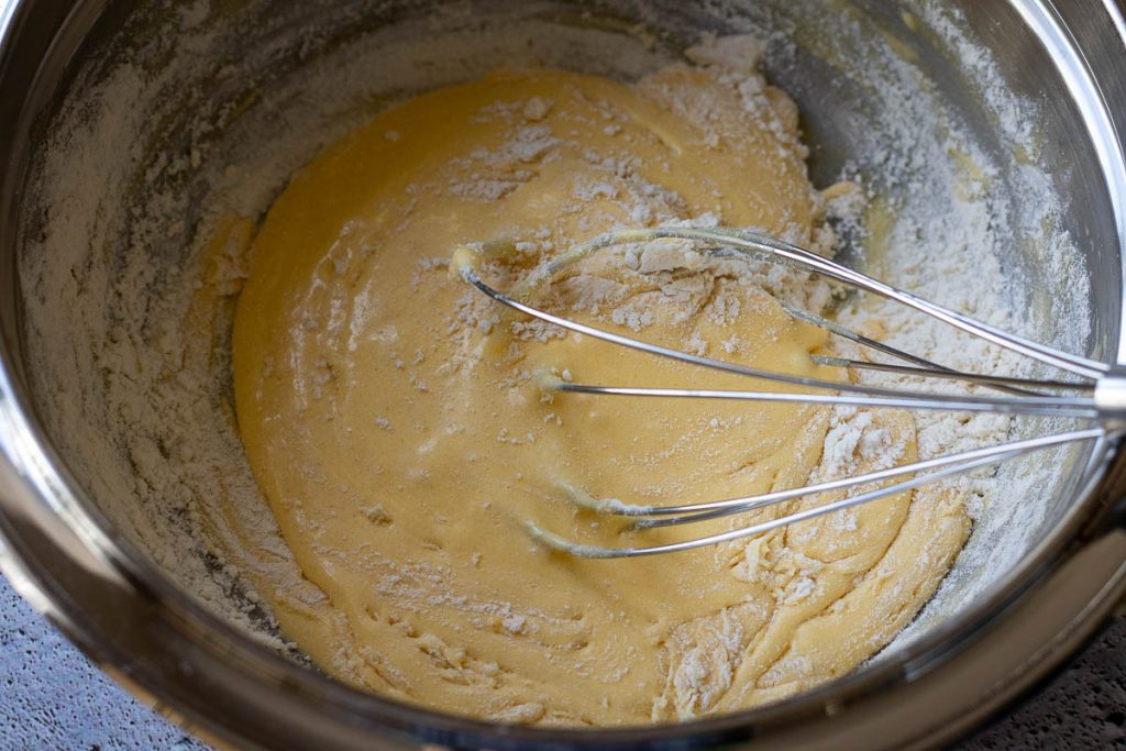 Mixing the flour into the eggs with a balloon whisk.