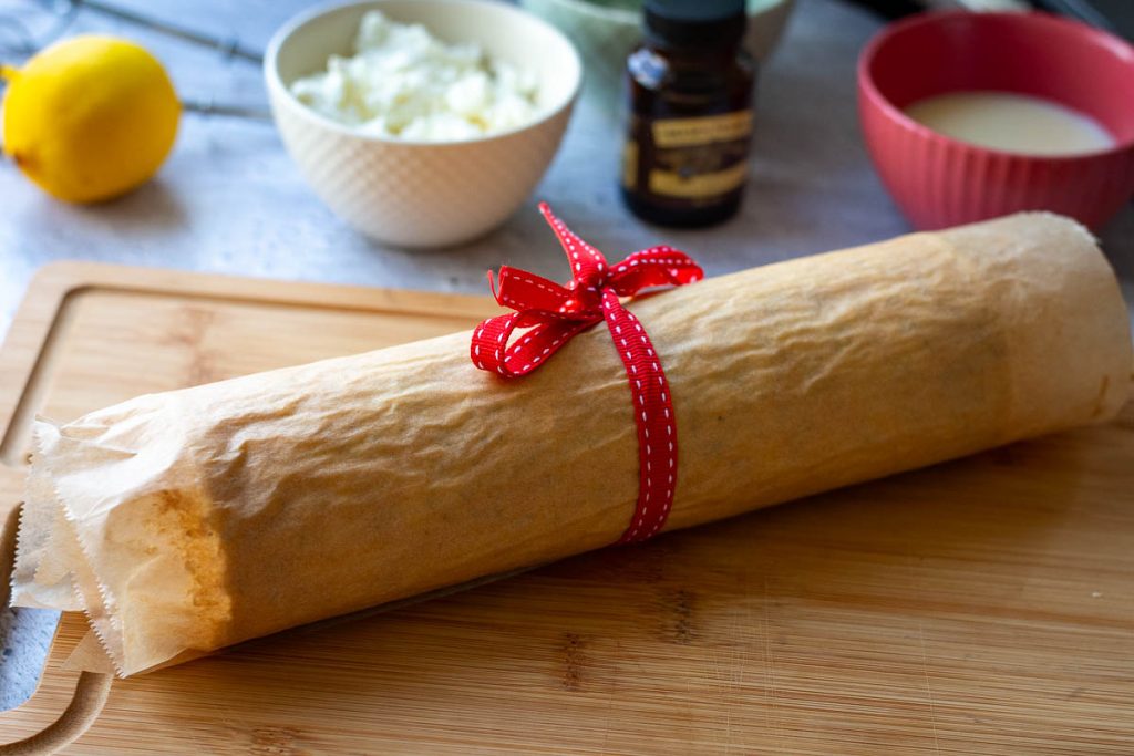 A red ribbon around the rolled sponge ensuring it stays rolled up.