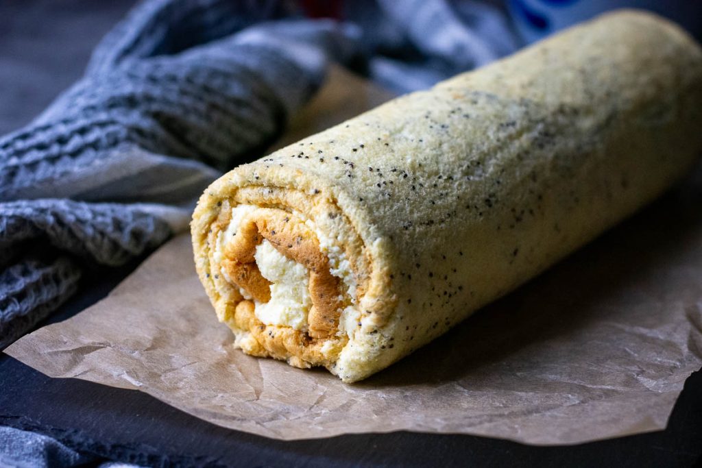 Rolled up Kursenu vyniotinis on a piece or parchment paper.