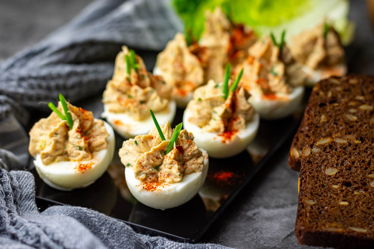 Lithuanian Deviled Eggs With Tuna with a sprinkling of paprika on top.