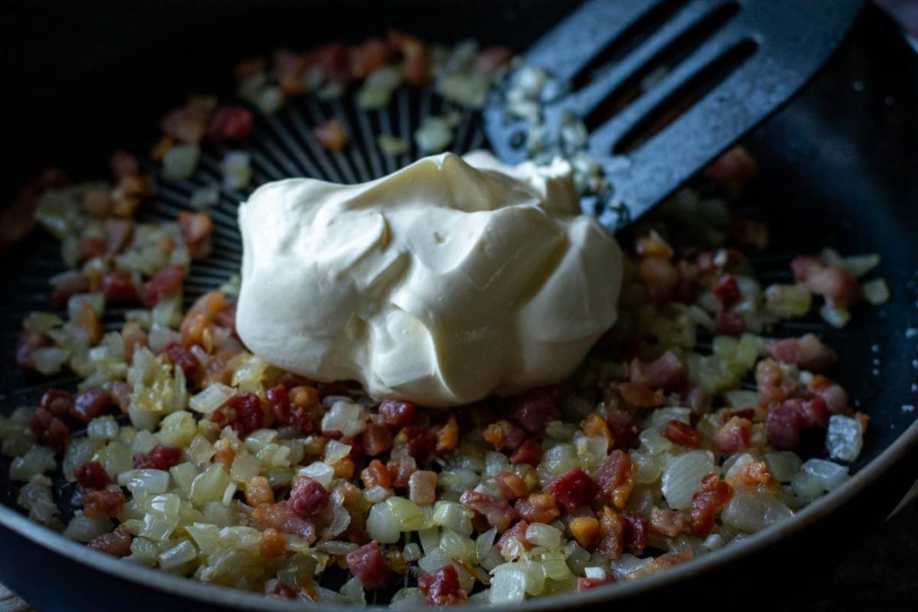 Sour cream added to the onion and bacon pan. 