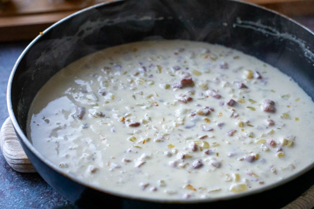 Sour cream sauce with bacon in a large frying pan, ready to be served. 