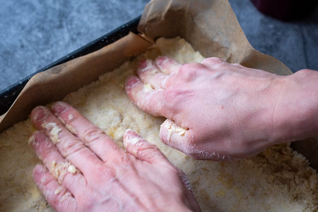 Pressing the base down with the palms of the hands. 