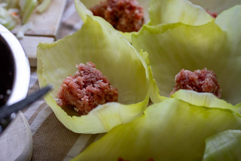 A large spoonful of Pork filling in each of the cabbage leaves. 