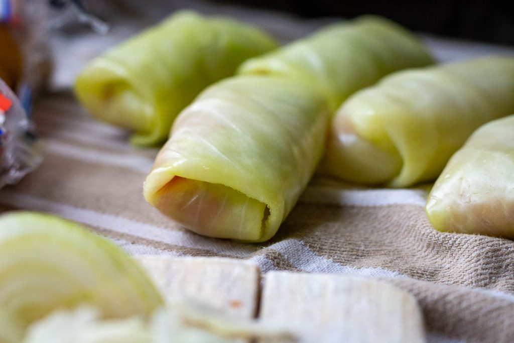 Rolling ground pork filling into a cabbage leaf to make Lithuanian Cabbage Roll. 