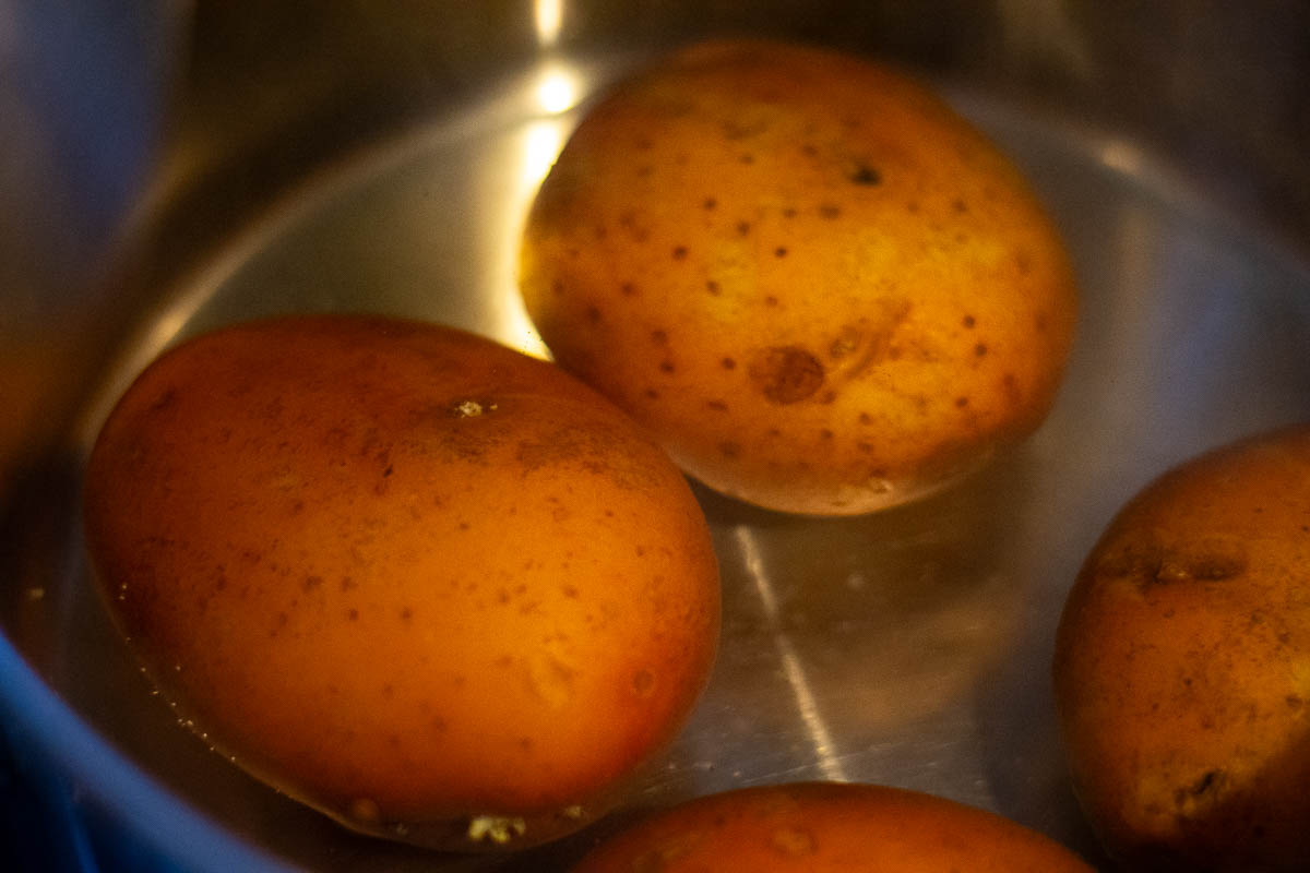Red skinned potatoes in water.