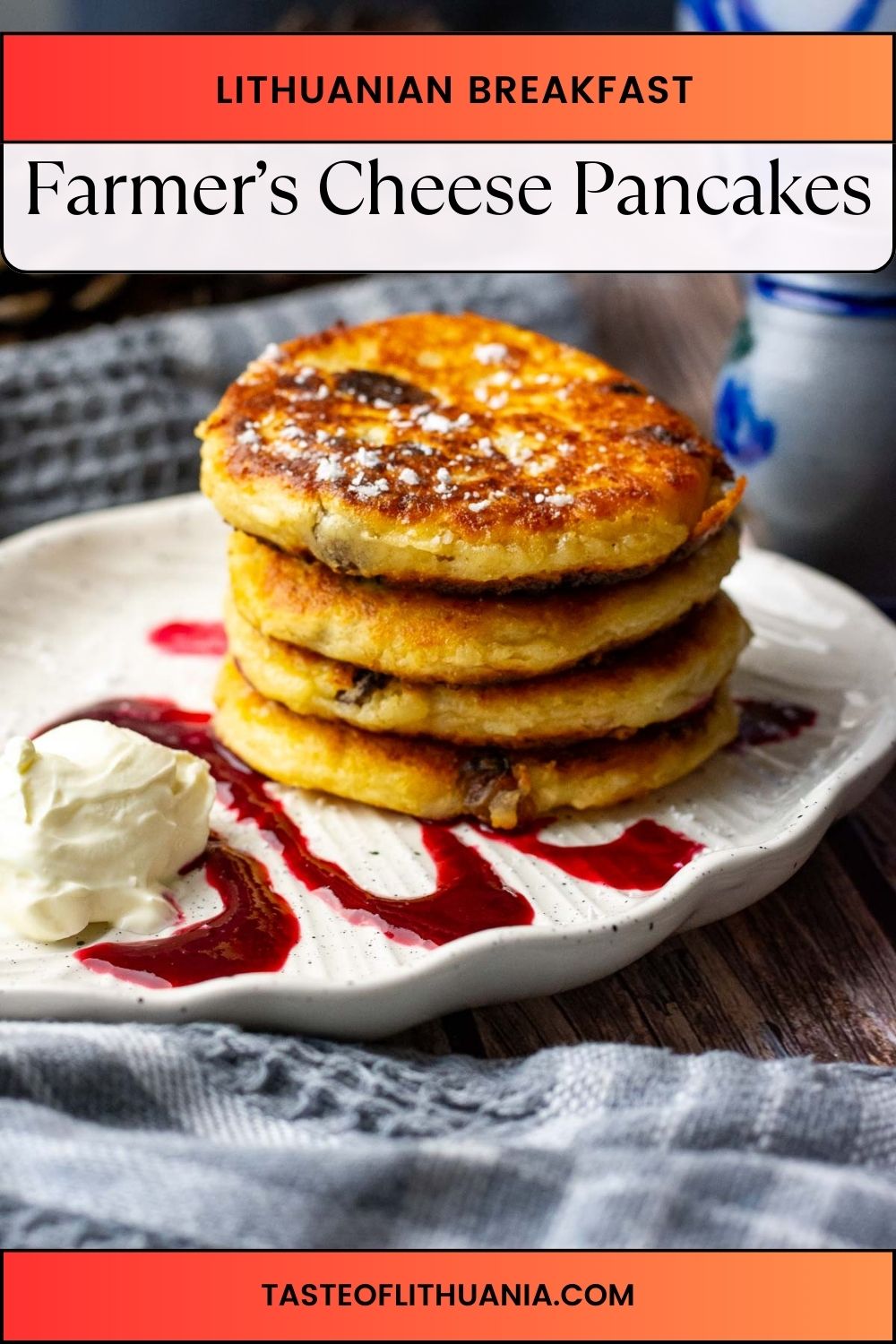 A stack of Lithuanian Farmer's Cheese Pancakes on a plate with sour cream and berry coulis. 
