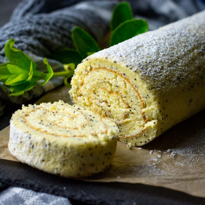 Lithuanian Farmers cheese roll with one slice cut on a piece of parchment paper.