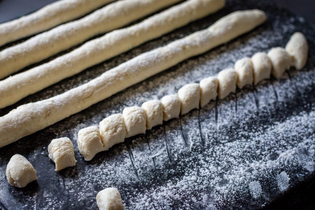 Cutting the dough into small dumplings. 