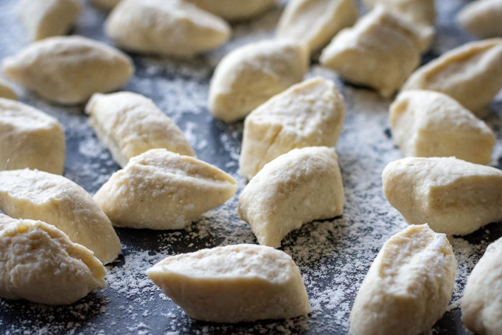 LIthuanian farmers cheese dumplings on a floured surface ready to be cooked. 