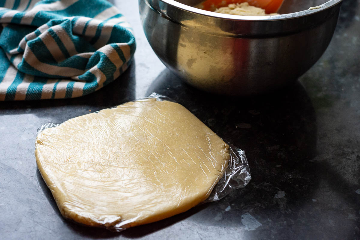 ⅔ of the dough in a metal bowl, and ⅓ of the dough flatenned and wrapped in plastic wrap.