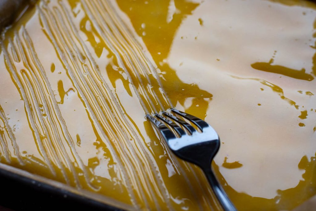 Using a fork to create lines in the egg yolk.