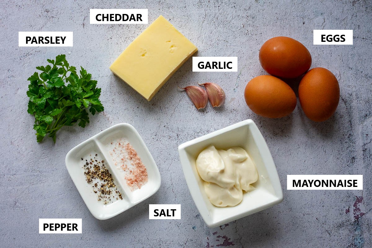 Ingredients for Lithuanian Salad with eggs and cheese on a grey surface,