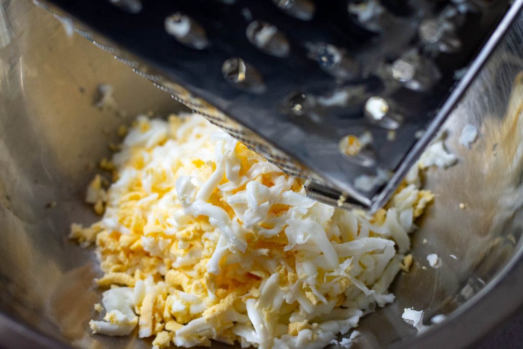Grated egg in a metal bowl.