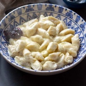 Lithuanian Farmers Cheese Dumplings in a white and blue bowl.
