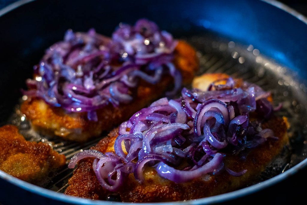 Cooked Lithuanian pork cutlets topped with softened onions.