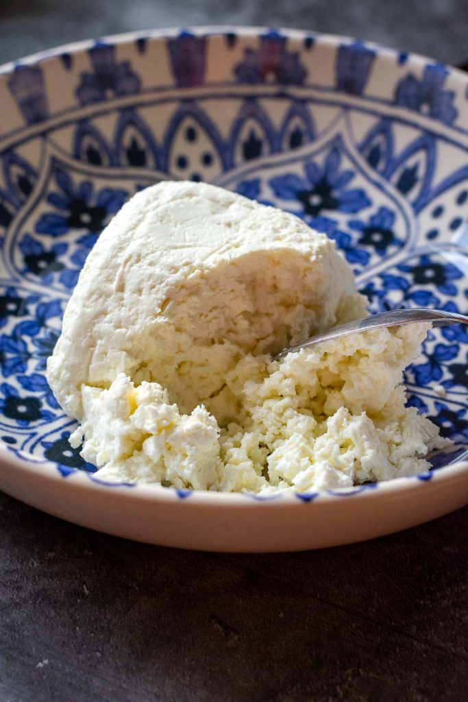 Breaking farmer's cheese up in a shallow bowl.