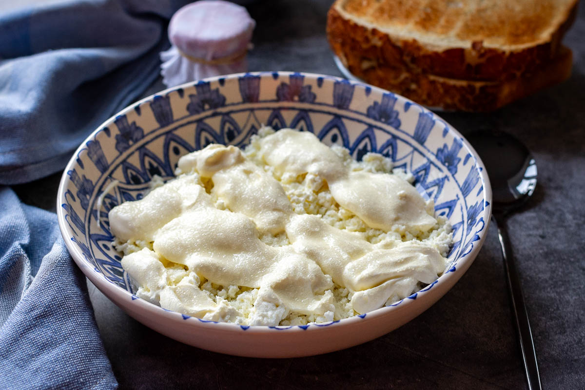 Farmers Cheese breakfast served with a small jar of jam and toasted bread.