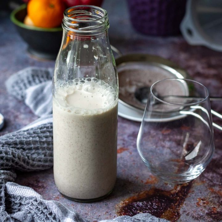 A glass milk bottle with Poppy Seed Milk on a Christmas Eve Table.