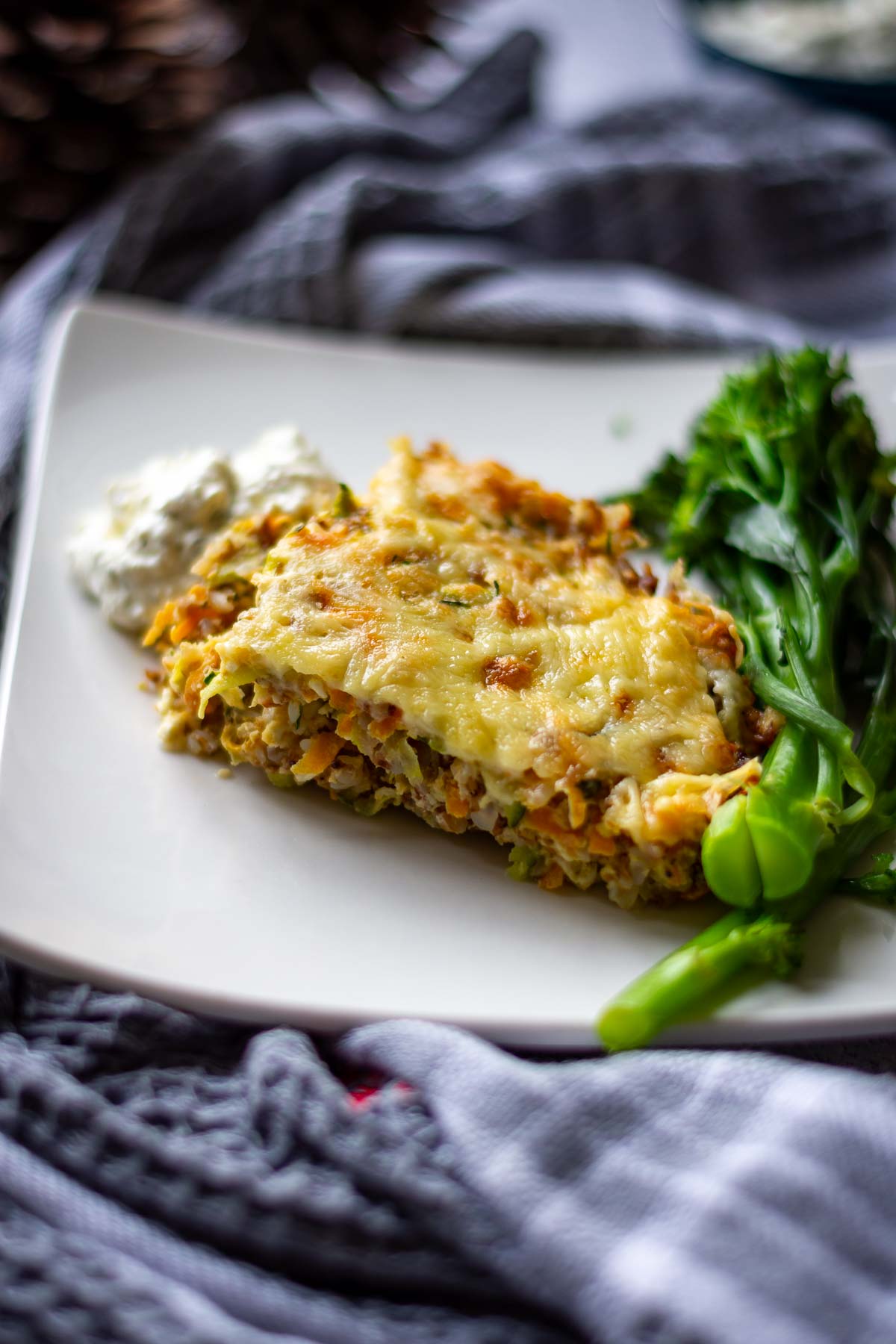 A portion of buckwheat casserole served with broccolini and farmers cheese dip.