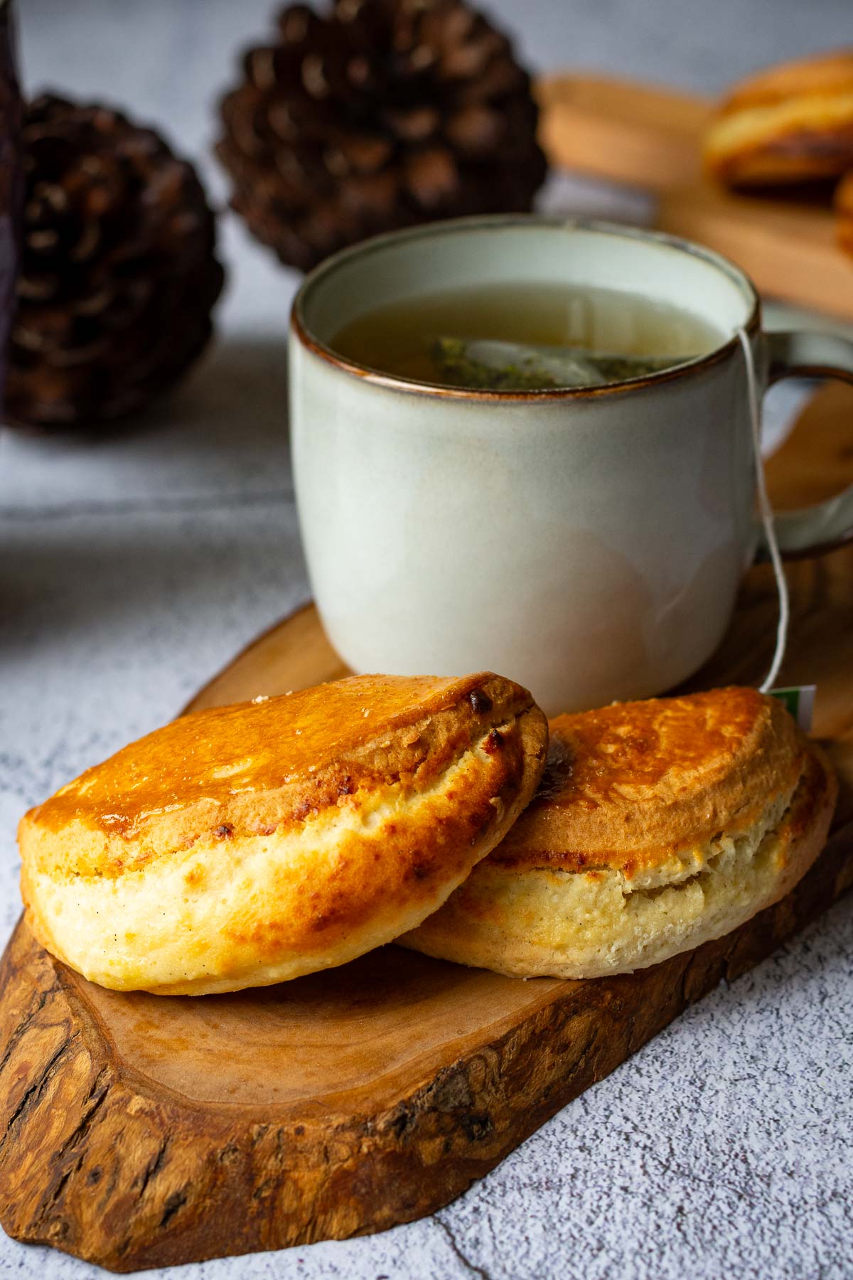 Two Lithuanian grietinieciai served with a cup of tea.