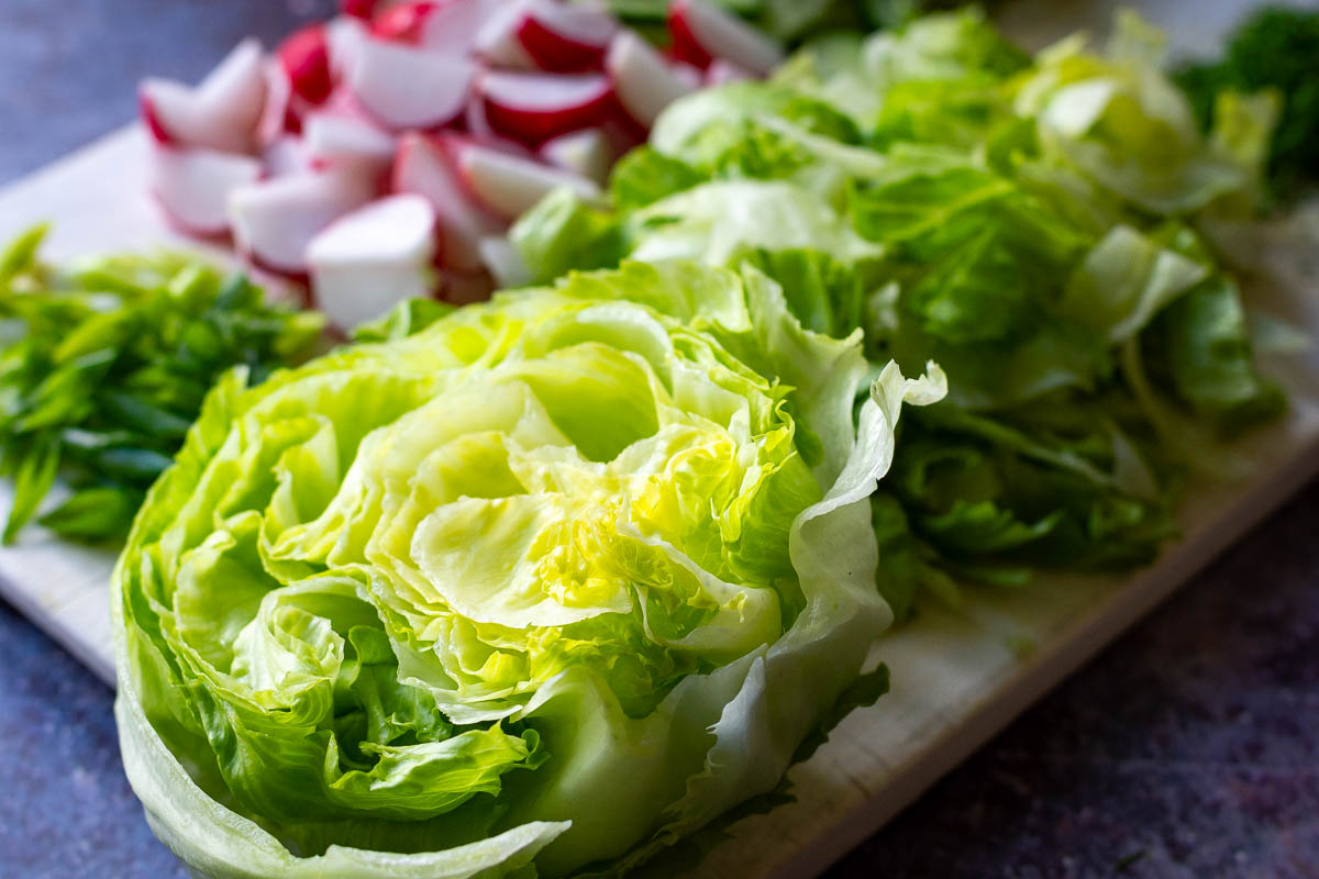 Vegetables for Lithuanian salad on a wooden chopping board. 