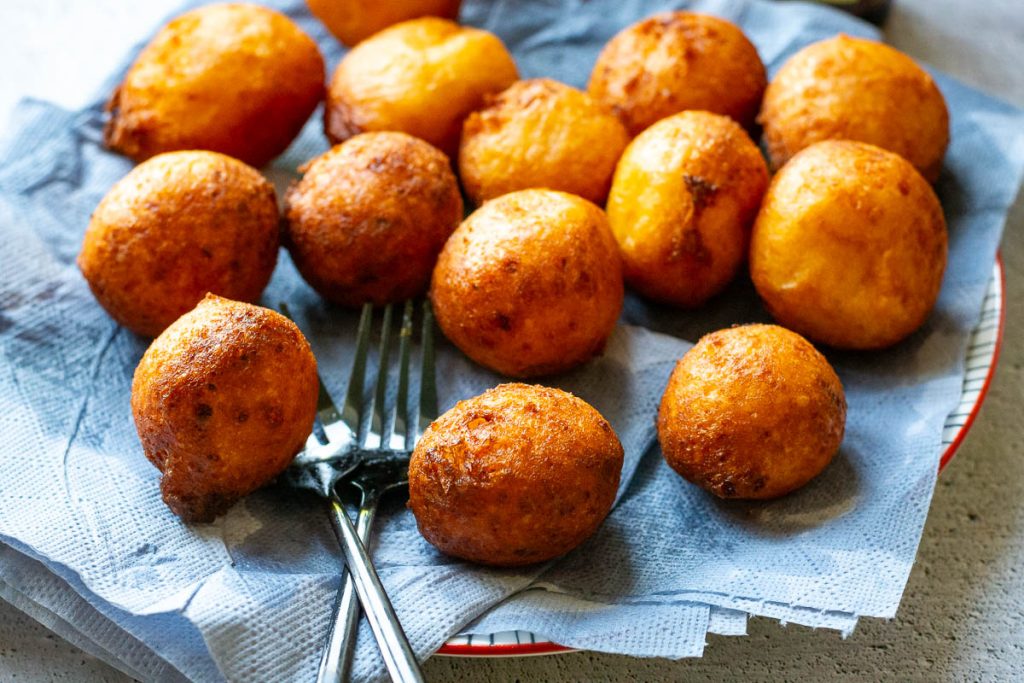 Curd Cheese doughnuts on a plate lined with kitchen towel.