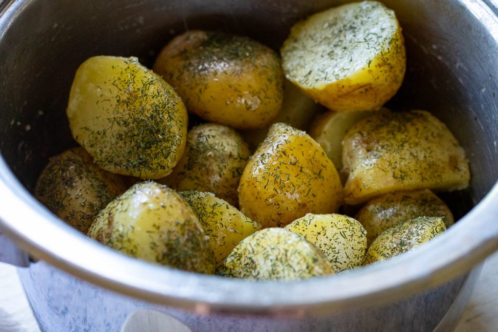 Boiled potatoes with dill and butter in a saucepan.