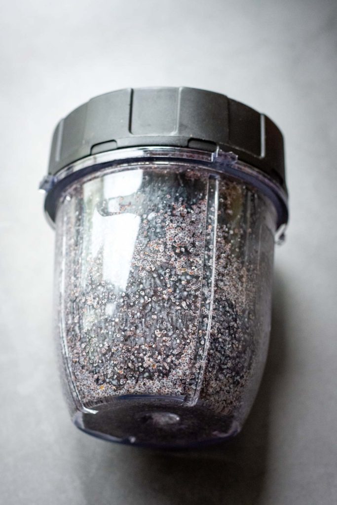 Mushed poppy seeds in a cup of a smoothie maker. 
