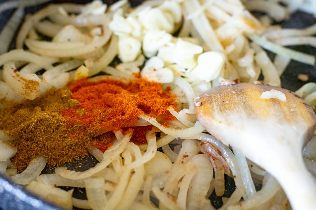 Onions, garlic and spices in a frying pan.