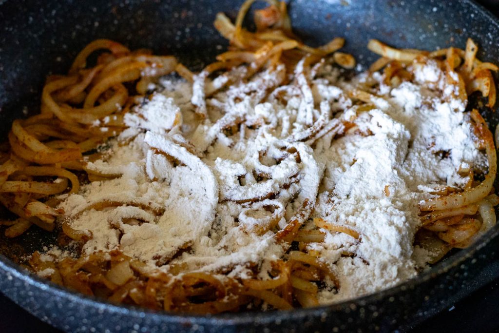 Flour sprinkled over the sauteed onions.