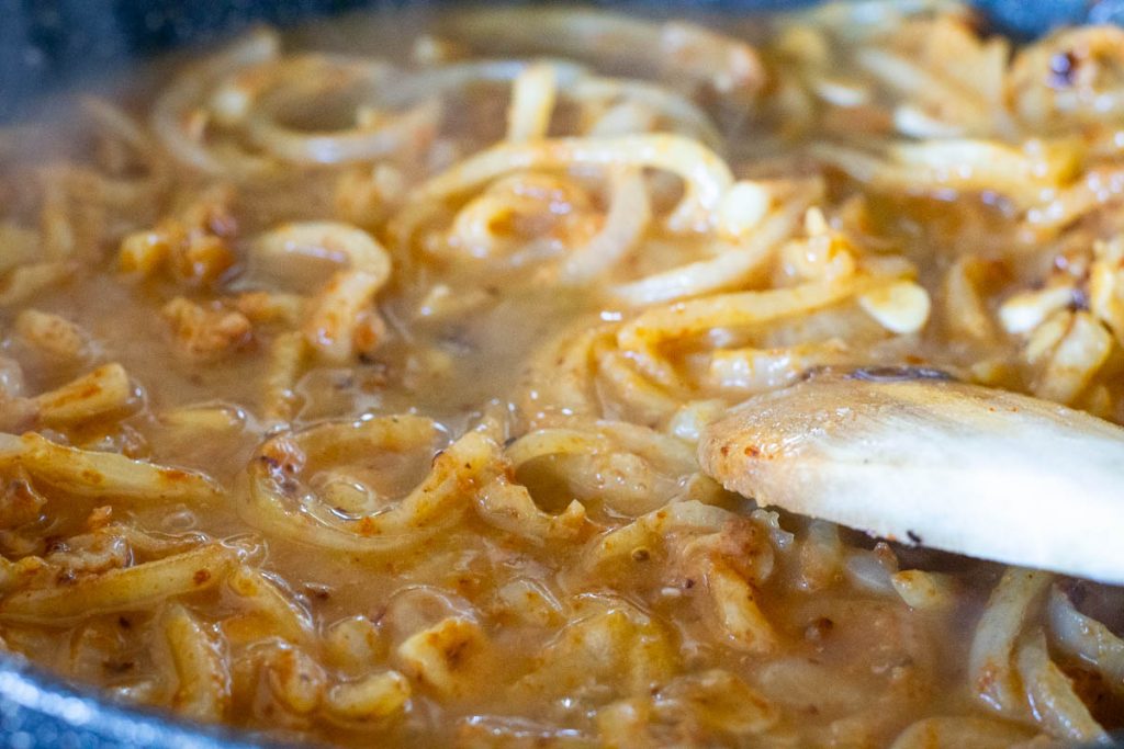 Stock poured into the onion and flour mixture to create an onion roux.