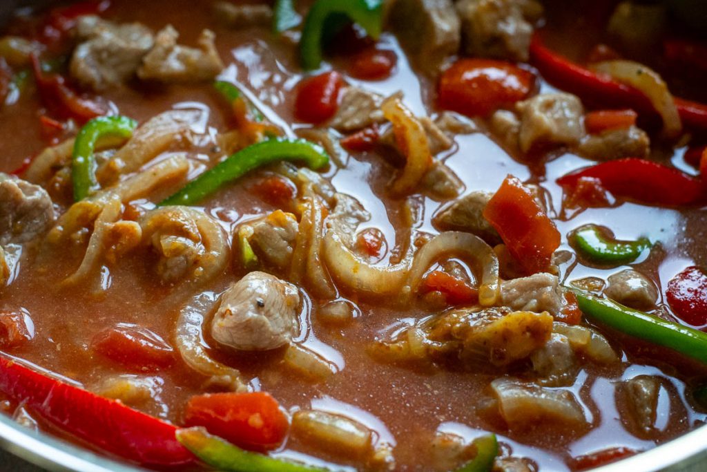 Pork and veggies simmering in a goulash sauce.