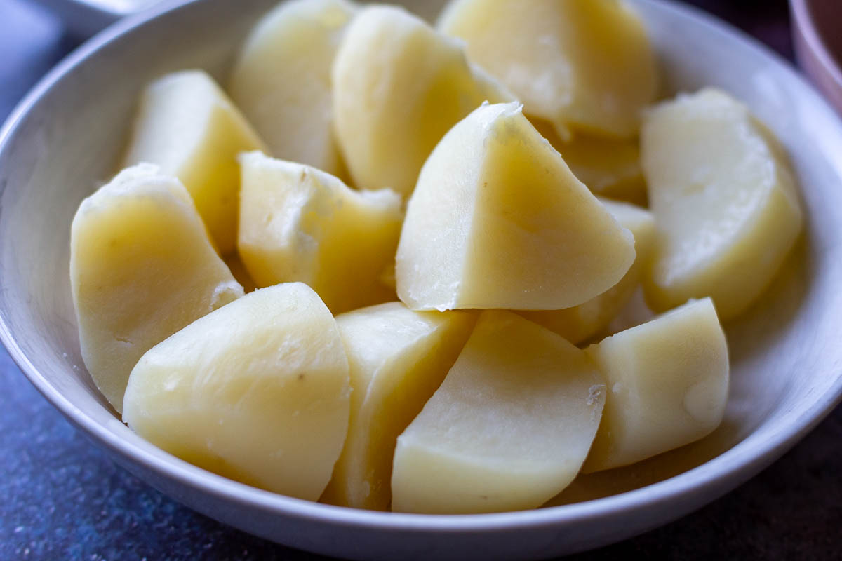 Boiled potatoes in a white bowl.