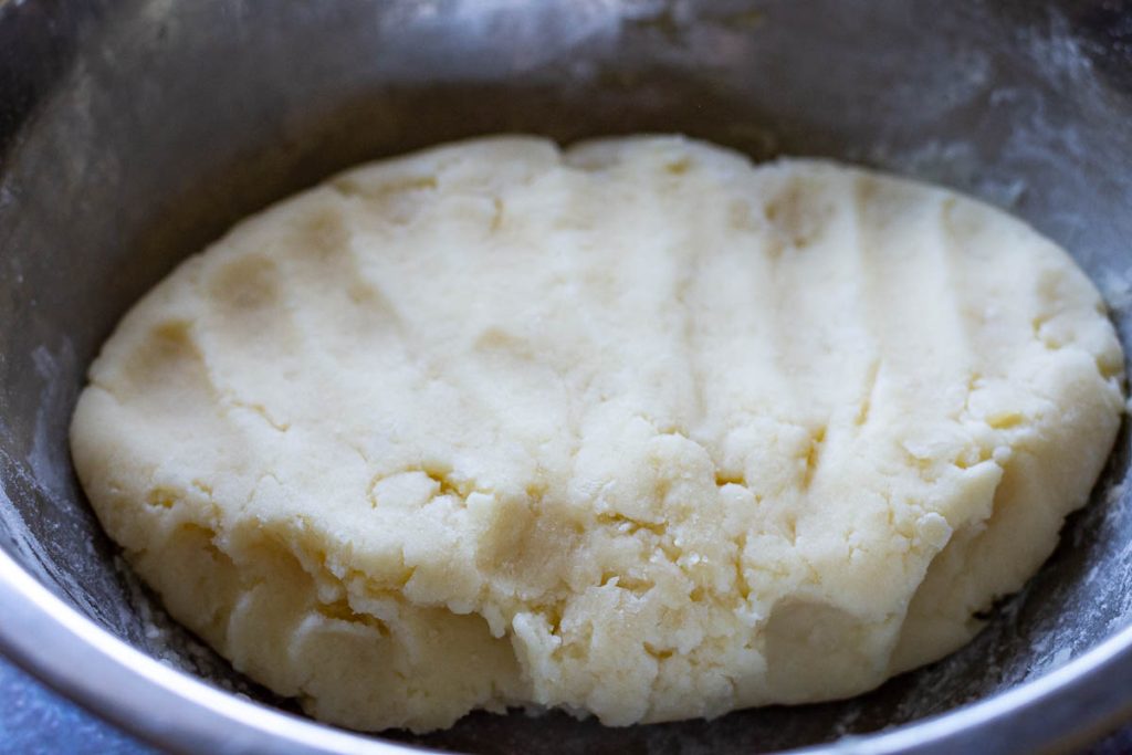 Mashed potato dough for Samogitian pancakes in a metal mixing bowl.