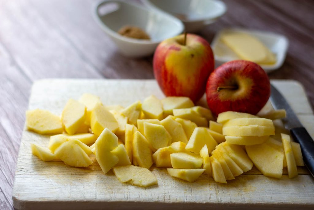 Slicing the apples on a wooden chopping board.