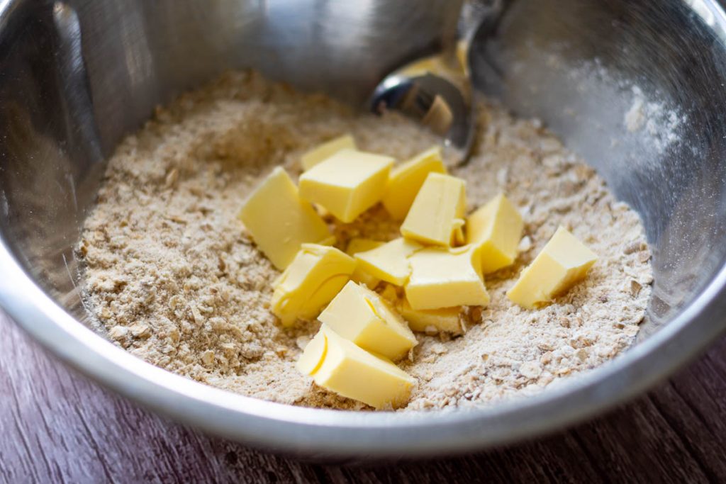 Cubed butter added to the dry crumble ingredients.