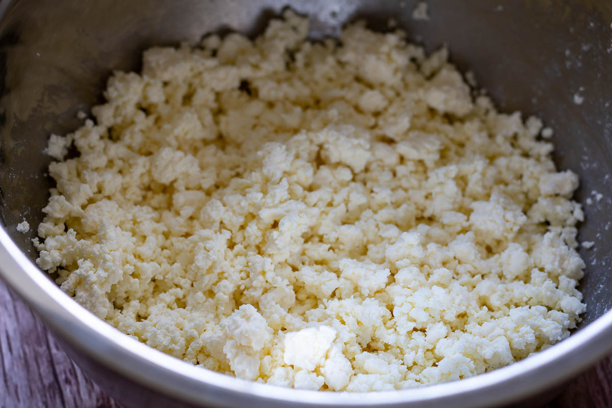 Farmer's cheese fluffed witha fork in a metal bowl.