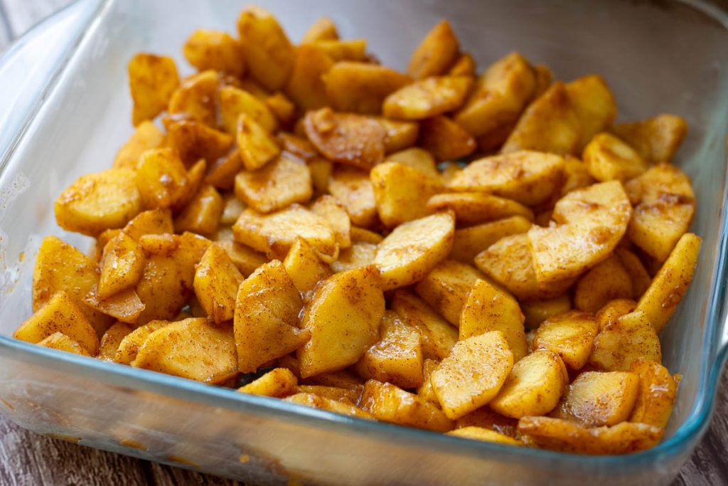 Stewed apples at the bottom of a casserole dish.