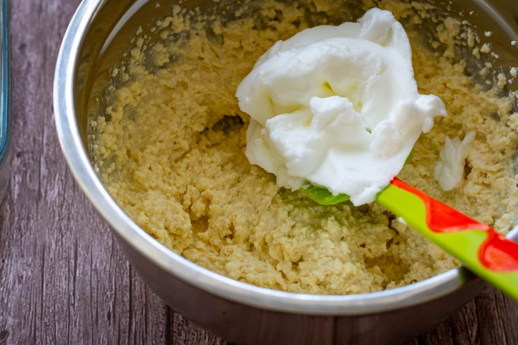 Folding the egg whits into the farmers cheese mixture using a green rubber spatula.