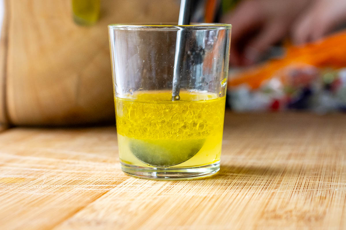 Carrot Salad dressing ingredinets mixed in a small shot glass.